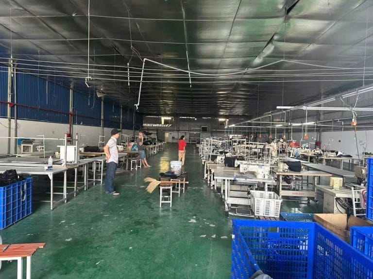 Không gian bên trong xưởng Tân Phước Khánh với máy móc, bàn làm việc và lối đi giữa xưởng